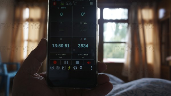 View of a smartphone showing altitude, interior view of a bedroom, Leh, Ladakh, North India, Himalayas, India