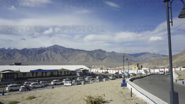 Taxis wait in Leh at the airport in front of surrounding mountains under a clear sky, Leh, Ladakh, North India, Himalayas, India