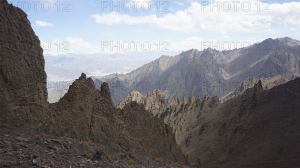 Rough, angular mountain formations under clear blue sky, trekking at Stok La Pass in Ladakh, Himalayas, India