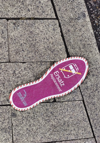 Purple footprint as a signpost on the pavement for rail replacement services, abbreviated SEV, Zug Info North Rhine-Westphalia, Siegen, North Rhine-Westphalia, Germany