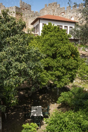 Alanya, Turkey. April 7th 2021 An empty table in a garden cafe inside the old castle walls of Alanya Red Tower, near the Mediterranean harbour, Turkey