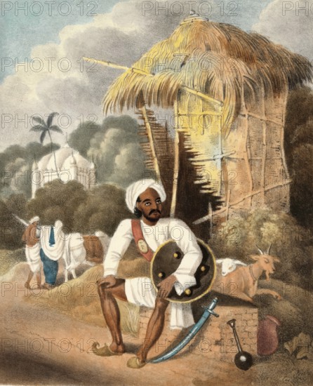 Police officer, guard in front of his dugout, village guard, India, authentic, digitally restored reproduction from a 19th century model, exact date of depiction unknown, historical, a man in traditional dress sitting in front of a hut with animals in the background