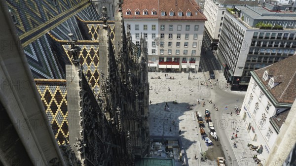 View from above of a lively square with church and coloured roof, Vienna