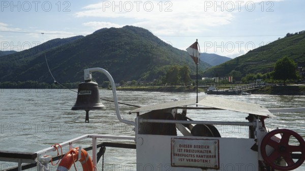 Ferry view of the Danube with flag and green mountains, long-distance cycle path, Danube cycle path, Austria