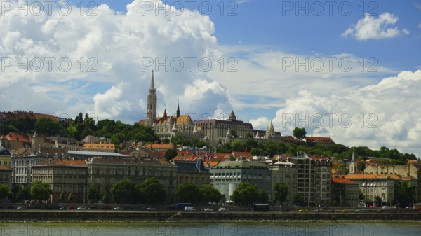 City view of the old town of Budapest, Historic buildings on a hill overlooking the Danube under a cloudy blue sky, Budapest