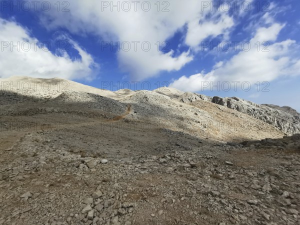 Rocky mountains with dramatic light and shadow effects in the sky, climbing Tahtali Dagi, Lycia, Turkey