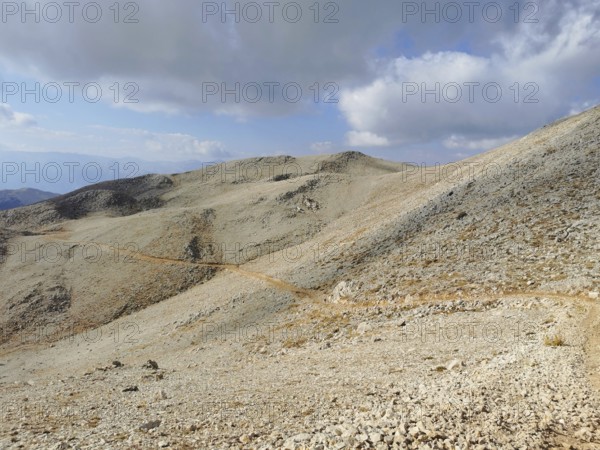 A narrow path snakes through a rocky mountain landscape, climbing Tahtali Dagi, Lycia, Turkey