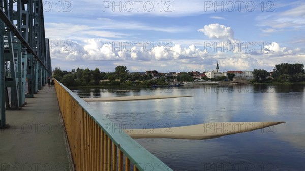River landscape with two sandbanks in the Vistula with metal bridge, clouds and view of Torun city, Poland