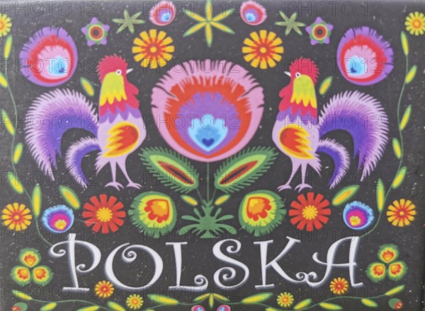 Colourful traditional Polish folk art with roosters and flowers on a black background and the inscription Polska, Poland
