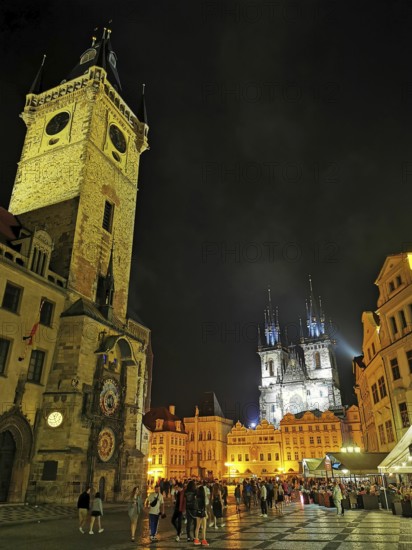 Night view, view of the historic Old Town Square with brightly lit buildings and towers and many people, Prague, Czech Republic