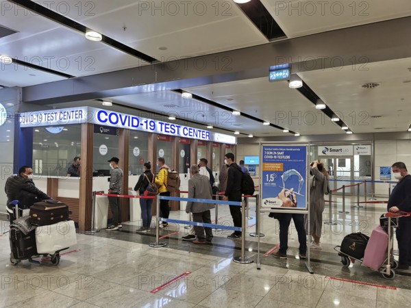 People are standing in a queue in front of a COVID-19 test center at the airport, Antalya, Turkey during corona
