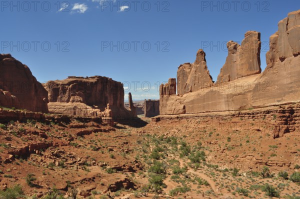 A wide valley with imposing sandstone cliffs, called Wall Street, under a bright blue sky, Arches National Park, Utah, USA