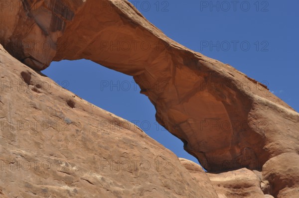 Skyline Arch, a massive sandstone arch in the desert under clear skies, Arches National Park, Utah, USA