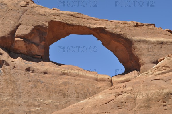 Skyline Arch, a sandstone arch under clear blue sky, Arches National Park, Utah, USA