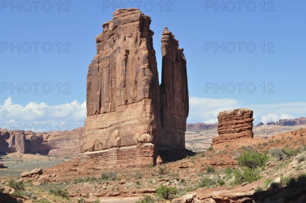 A colossal rock formation rises in a vast desert landscape, Arches National Park, Utah, USA