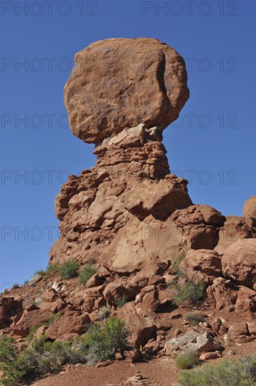 A massive, balanced rock formation in the midst of a barren desert landscape, Arches National Park, Utah, USA