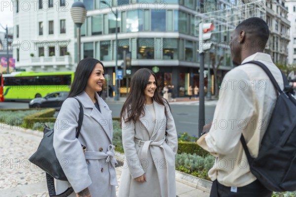 Young multiracial friends meeting on an urban street, engaging in a pleasant conversation, embodying concepts of connection, community, and social interaction in a modern city environment