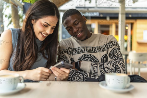 Diverse interracial couple smiling and sharing content on a smartphone at an outdoor cafe, enjoying coffee, casual date vibes, connection and relaxed summer city leisure