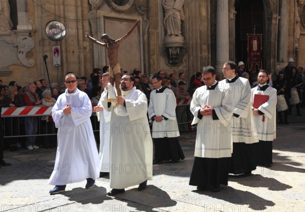Sicily, Trapani, people and groups accompany the La Processione dei Misteri mystery procession through the old town, in front of the Chiesa del Purgatorio church