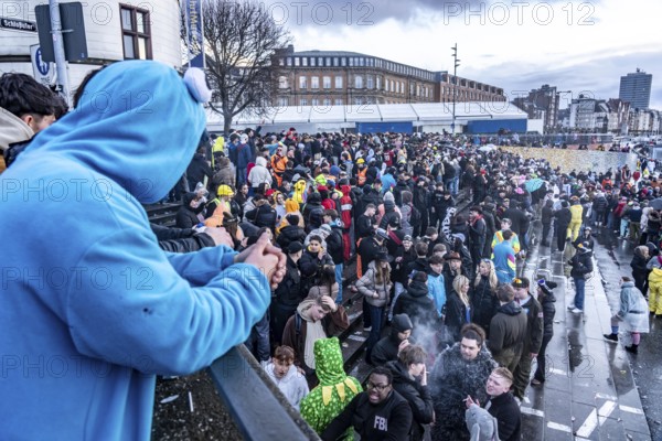 Banks of the Rhine on the old town, despite rainy weather, many, mostly young people gather here to celebrate on Rose Monday in Düsseldorf, North Rhine-Westphalia, Germany