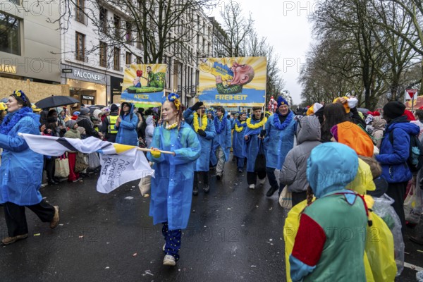 Members of the Blau-Gelbes Kreuz association, German-Ukrainian Association e.V., as a foot group at the Düsseldorf Rose Monday procession, show pictures with motifs from previous carnival motifs by the wagon manufacturer Jacques Tilly, who denounces Russia's war against Ukraine, a criminal case is therefore being brought against him in Russia, expression of solidarity for Tilly, North Rhine-Westphalia, Germany