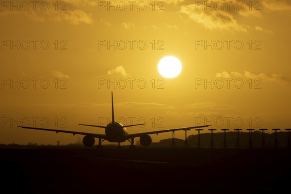 Boeing 777 A7-BFL commercial jet aircraft of Qatar cargo waiting to take off silhouette at sunset at London Stansted airport, Essex, England, United Kingdom