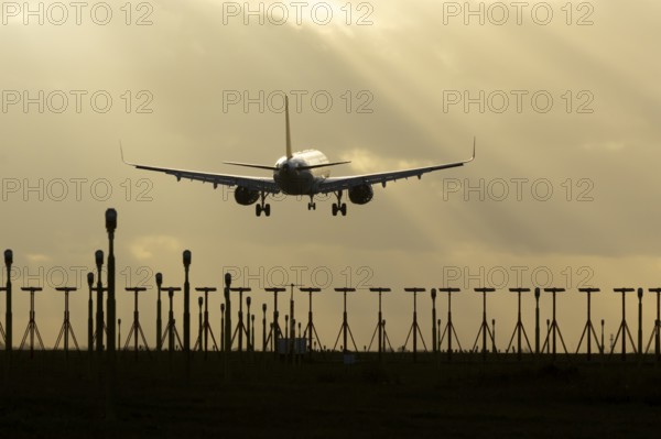 Airbus A321 commercial passenger airliner jet aircraft of Pegasus airlines flying on approach to land over runway lights at sunset at London Stansted airport, Essex, England, United Kingdom