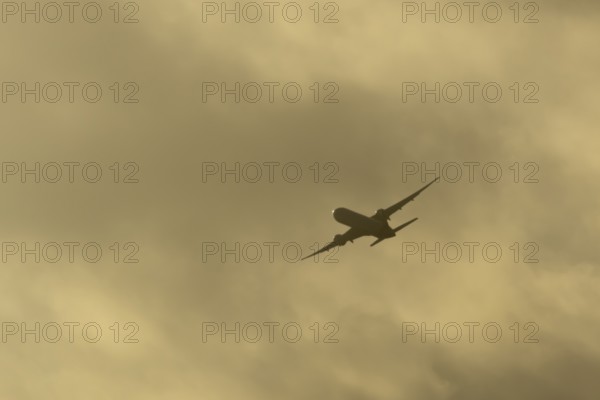 Commercial passenger airliner jet aircraft in flight at sunset at London Stansted airport, Essex, England, United Kingdom