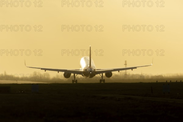 Boeing 777 commercial passenger airliner jet aircraft landing on a runway at sunset at London Stansted airport, Essex, England, United Kingdom