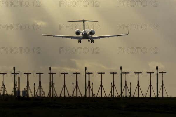 Executive business jet aircraft in flight on approach to land at sunset at London Stansted airport, Essex, England, United Kingdom