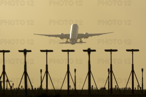 Commercial passenger airliner jet aircraft taking off in flight at sunset at London Stansted airport, Essex, England, United Kingdom