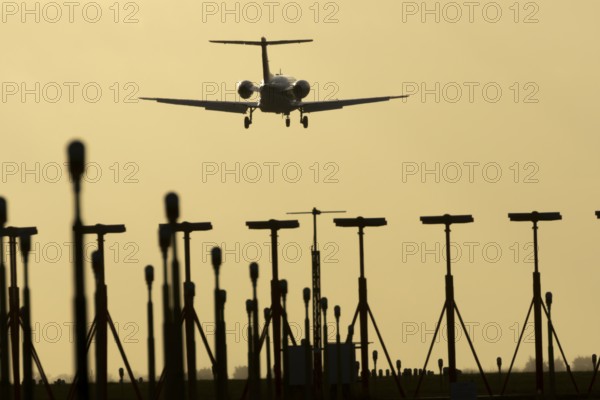 Cessna Citation small executive business jet aircraft in flight on approach to land over runway lights at sunset at London Stansted airport, Essex, England, United Kingdom