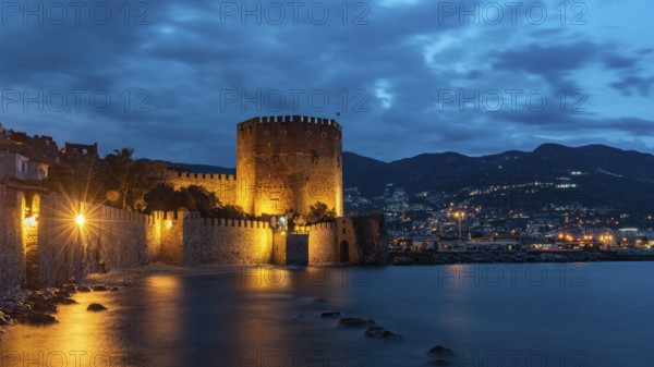 Alanya, Turkey, April 9th 2021 Stunning panorama of Alanya Harbour and the Red Tower at night with the Taurus Mountains and Mediterranean Sea, Turkey