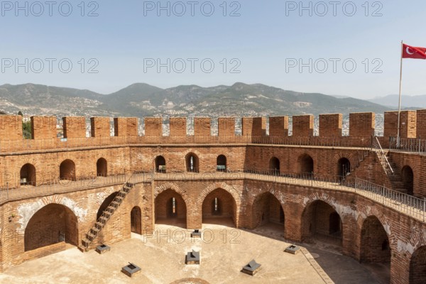 Alanya, Turkey. April 7th 2021 The imposing battlements of the Seljuk era Red Tower or Kizi Kule overlooking Alanya harbour with the Taurus Mountains in the background