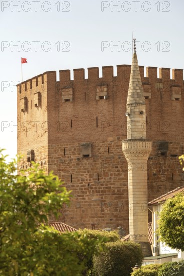 Alanya, Turkey. April 7th 2021 Mineret of Haci Kadiroglu Mosque in front of the famous Red Tower in Alanya harbour, southern Turkey