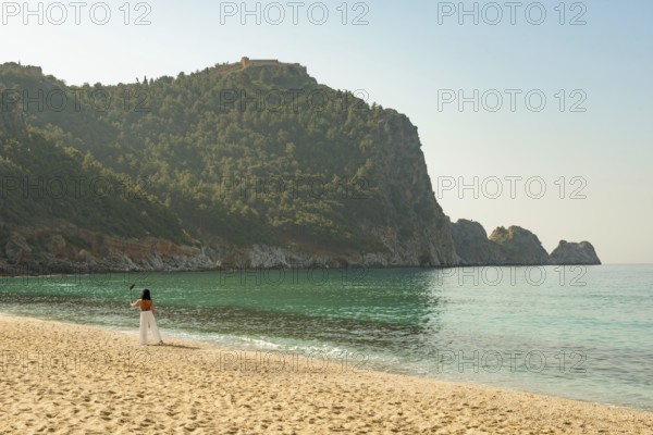 Alanya, Turkey. April 7th 2021 Beautiful woman taking a selfie on a bright sunny Kleopatra beach in the Turkish Mediterranean resort town of Alanya, Turkey