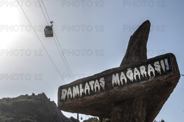 Alanya, Turkey. April 7th 2021 Entrance to Damlatas Magarasi with a cable car passing by. The cave and Teleferic are tourist attractions in the Turkish seaside resort of Alanya, Turkey