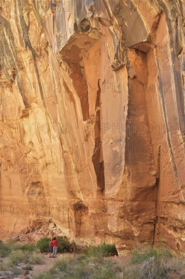 Impressive rock cliff with people below, showing the massive size and natural beauty, Capitol Reef National Park, Utha, USA
