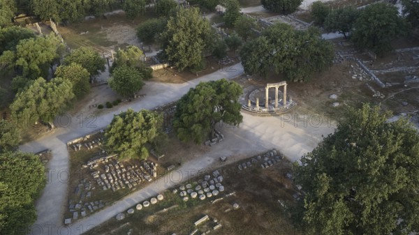 Soft morning light, Philippeion, ancient ruins with a round temple surrounded by paths and trees, drone shot, archaeological site, Ancient Olympia, Olympia, Peloponnese, Greece