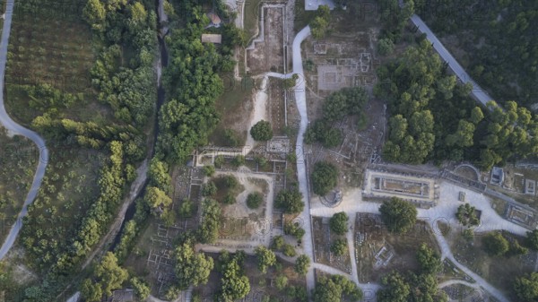 Olympic excavation site from high altitude, Temple of Zeus, Temple of Hera, Leonidaion, Palestra Philippeion, etc. Historic ruin road embedded in a wooded landscape, taken from the air, drone shot, archaeological site, Ancient Olympia, Olympia, Peloponnese, Greece