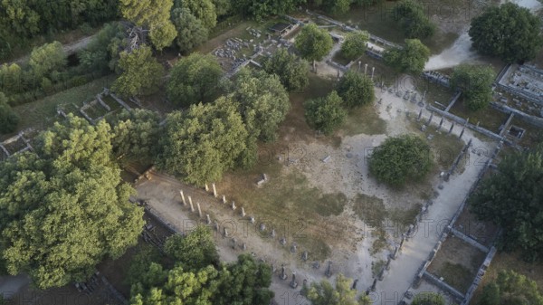 Palestra in morning light, ancient columns and ruins in the middle of a dense forest area, taken from the air, drone shot, archaeological site, Ancient Olympia, Olympia, Peloponnese, Greece