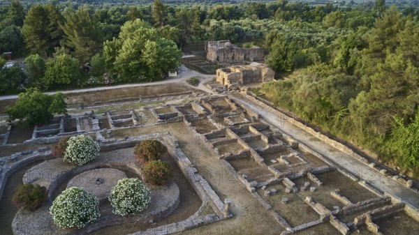 Soft morning light, part of Leonidaion, archaeological remains with foundations and surrounding lush vegetation, drone shot, archaeological site, Ancient Olympia, Olympia, Peloponnese, Greece