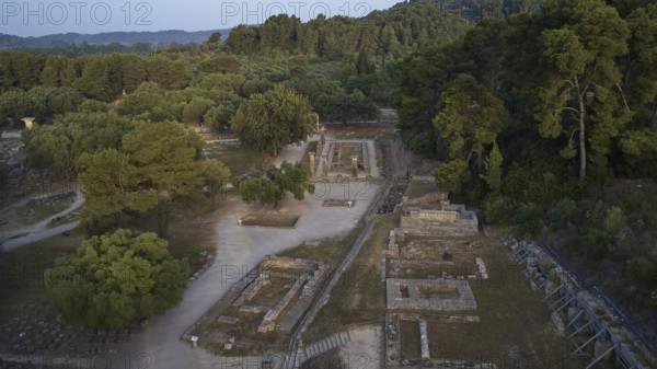 Soft morning light, Temple of Hera, ruins and thick forests in hilly surroundings, drone shot, archaeological site, Ancient Olympia, Olympia, Peloponnese, Greece