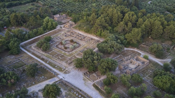 Soft morning light, Leonidaion, workshop of Phidias and early Christian Bailica, Heroon, Theocoleon, aerial view of ancient ruins surrounded by thick forest and trails, drone shot, archaeological site, Ancient Olympia, Olympia, Peloponnese, Greece