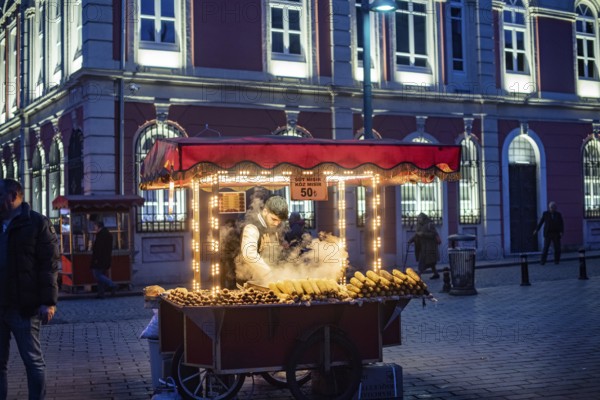Istanbul, Turkey. January 3rd 2025. A street stall vendor selling sweet corn and roasted chestnuts, traditional street food in Istanbul at night, Turkey