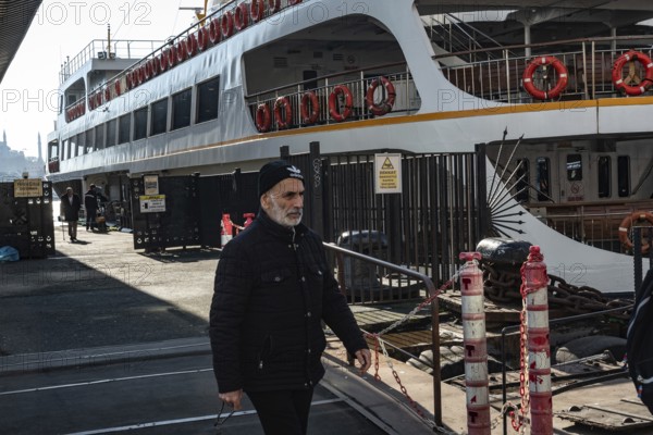 Istanbul, Turkey. January 3rd 2025. A Turkish man disembarks a ferry docked at Karakoy ferry port on the Bosporus Straight separating the Asian and European sides of Istanbul, Turkey