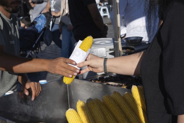 Istanbul, Turkey. September 18th 2025. A customer buying freshly boiled sweet corn known as Misr in Turkish, a popular street food sold all over Turkey from street cart vendors
