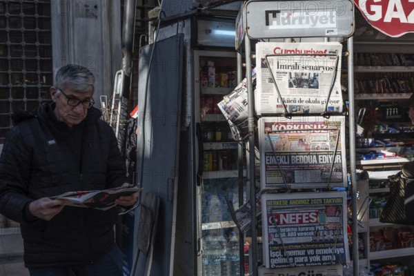 Istanbul, Turkey. January 7th 2025. A Turkish man reads a newspaper outside a news stand in the Karakoy district of Istanbul, Turkey