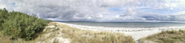 Wide beach with dunes and sea under dramatic sky, Rügen, Baltic Sea