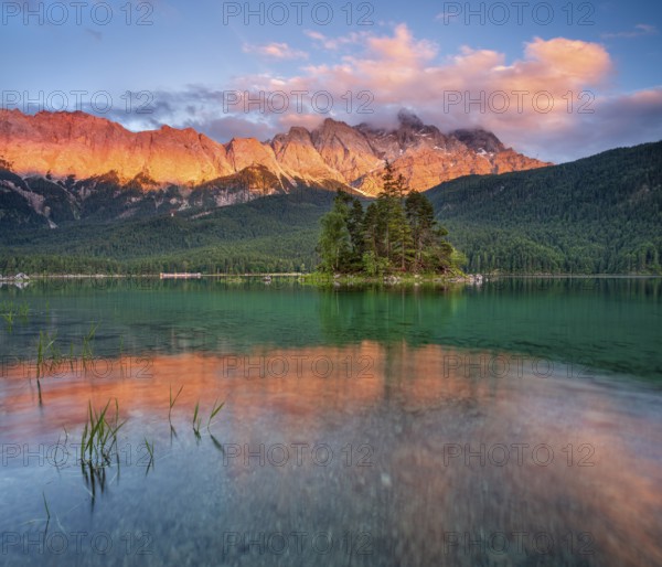 Evening atmosphere on Lake Eibsee lake with alpine glow, in the back the Wetterstein Mountains with the Zugspitze, clouds sweeping over the peaks, Grainau, Garmisch-Partenkirchen, Bavaria, Germany